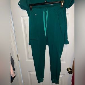 The hunter green Catarina One-Pocket Scrub Top™ and Zamora Jogger Scrub Pants™